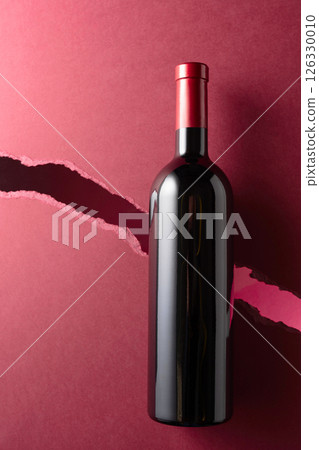 Bottle of red wine on a dark red background. Bottle of red wine on a dark red background. 126330010