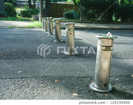 Car stop poles lined up along the park road Car stop poles lined up along the park road 126330406