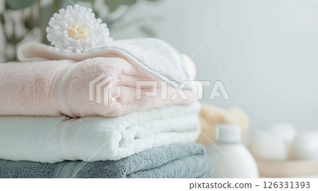 A stack of towels with a flower on top A stack of towels with a flower on top 126331393