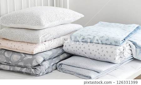 A stack of bedding with a blue and white blanket on top A stack of bedding with a blue and white blanket on top 126331399