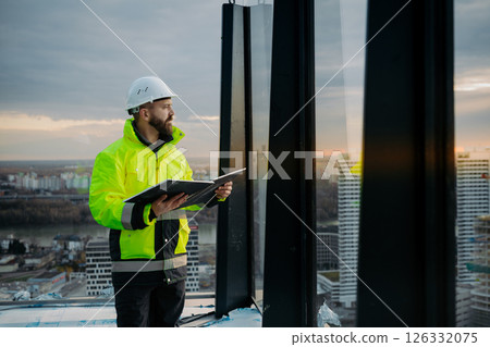 Engineer overseeing city construction project, reading documentation. 126332075