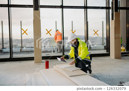 Construction site manager using digital tablet to inspect building progress. 126332079