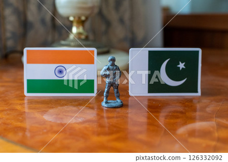 A tin soldier on the background of the flags of India and Pakistan. India Pakistan military conflict 126332092