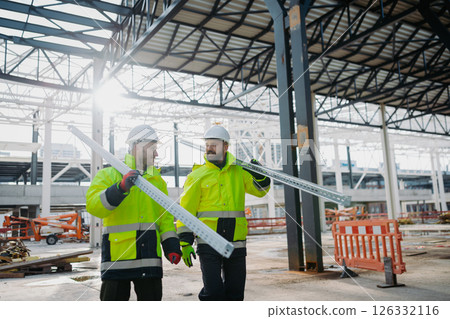 Construction workers at work on modern building site. 126332116