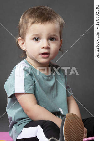 Portrait of a little funny girl, one and a half years old, wearing a sports T-shirt. 126332383