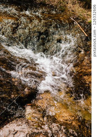 Crystal clear water flows over moss covered rocks, creating mesmerizing cascade in pristine natural setting, showcasing beauty and tranquility of untouched wilderness. Water cascading over moss rocks Crystal clear water flows over moss covered rocks, creating mesmerizing cascade in pristine natural setting, showcasing beauty and tranquility of untouched wilderness. Water cascading over moss rocks 126332606
