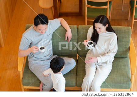 A Japanese couple relaxing with their child in the living room 126332964