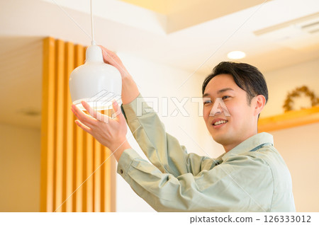 A Japanese man wearing work clothes inspecting the home's facilities 126333012