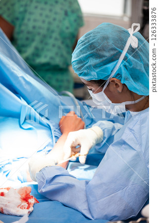 Female doctor performing a surgery. Orthopedic surgeon. Surgery and insurance concept. 126333876