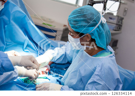 Female doctor performing a surgery. Orthopedic surgeon. Surgery and insurance concept. 126334114