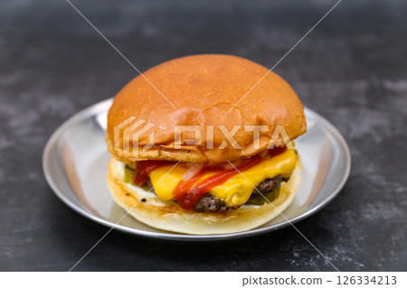 A cheeseburger is on a plate 126334213