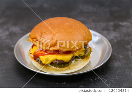 A cheeseburger is on a plate 126334214