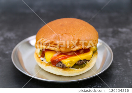 A cheeseburger is on a plate 126334216