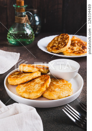 Crispy mashed potato pancakes and gravy on a plate on the table vertical view Crispy mashed potato pancakes and gravy on a plate on the table vertical view 126334489