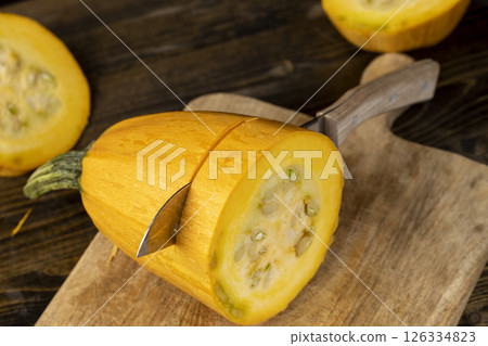 Slice yellow pumpkin or zucchini, slicing ripe zucchini on a black table, close up Slice yellow pumpkin or zucchini, slicing ripe zucchini on a black table, close up 126334823