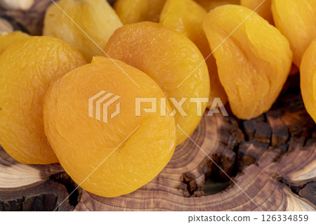 a lot of dried dried apricots are dehydrated after removing the seeds, apricots on a wooden board 126334859