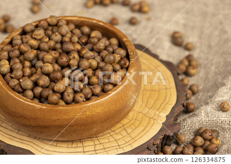 fried but not boiled chickpeas are on the table with a linen tablecloth, porridge is poured in a bowl, side view fried but not boiled chickpeas are on the table with a linen tablecloth, porridge is poured in a bowl, side view 126334875