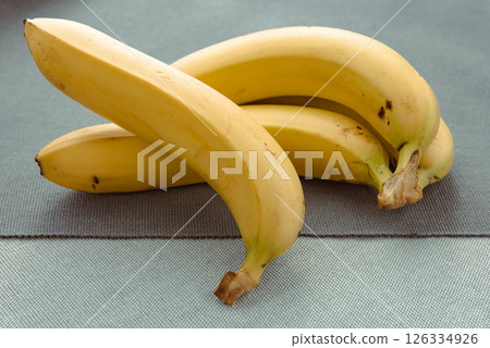 bunch of ripe bananas on the gray background with early morning sunlight shines through bunch of ripe bananas on the gray background with early morning sunlight shines through 126334926