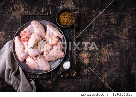 Raw chicken wings on black background. 126335333