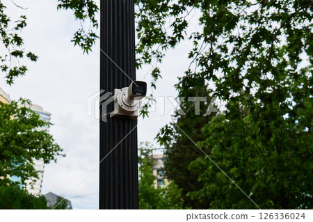 A surveillance camera monitors the area from a street pole 126336024