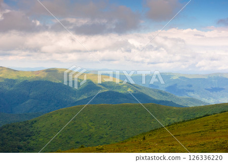 summer landscape with mountain range in cold weather. carpathian watershed ridge and wonderful alps in the distance. alpine scenery under cloudy sky in dappled light 126336220