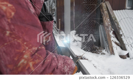 A dedicated person working hard in a snowy environment, diligently clearing snow for both safety and accessibility 126336529