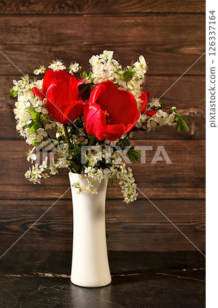 Abstract floral arrangement and banner for screen, Still life with beautiful spring branches of blooming bird cherry, cherry and red tulips in vase on elegant background. Floral holiday card with Abstract floral arrangement and banner for screen, Still life with beautiful spring branches of blooming bird cherry, cherry and red tulips in vase on elegant background. Floral holiday card with 126337164