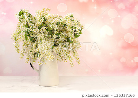 Abstract floral arrangement and banner for screen, Still life with beautiful spring branches of blooming bird cherry in vase on elegant background.Floral holiday card with summer greeting concept Abstract floral arrangement and banner for screen, Still life with beautiful spring branches of blooming bird cherry in vase on elegant background.Floral holiday card with summer greeting concept 126337166