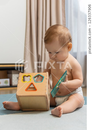 Sweet caucasian baby boy sitting on floor and playing 126337906