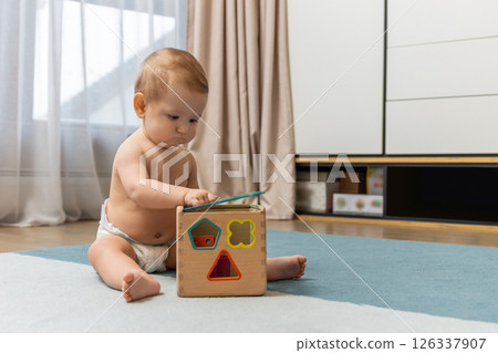 Sweet caucasian baby boy sitting on floor and playing 126337907