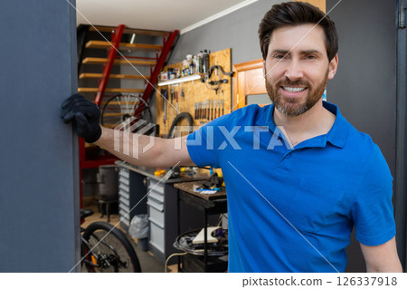 Mechanic leaning against wall in workshop Mechanic leaning against wall in workshop 126337918