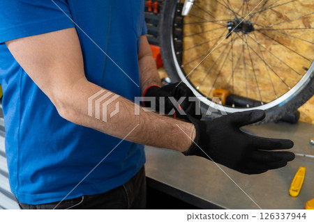 Mechanic putting on black gloves Mechanic putting on black gloves 126337944