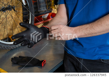 Mechanic putting on black gloves 126337945