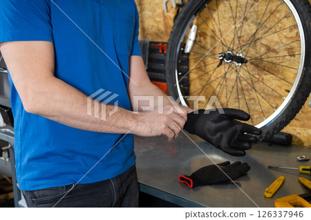 Mechanic putting on black gloves Mechanic putting on black gloves 126337946