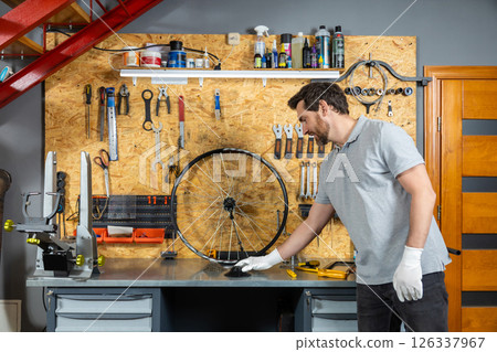 Mechanic in white gloves working on wheel Mechanic in white gloves working on wheel 126337967