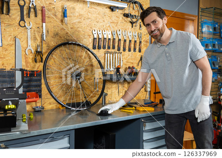 Mechanic in white gloves inspecting wheel Mechanic in white gloves inspecting wheel 126337969