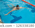 Man in black swimming cap swimming crawl style in the pool 126338180