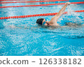 Man in black swimming cap swimming crawl style in the pool 126338182