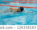 Man in black swimming cap swimming crawl style in the pool 126338183