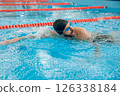 Man in black swimming cap swimming crawl style in the pool 126338184