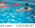 Man in black swimming cap swimming crawl style in the pool 126338187