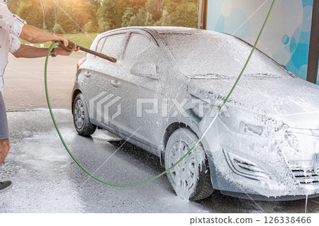 Car cleaning. Man washing car with spray. Foam water soap self service. Car cleaning. Man washing car with spray. Foam water soap self service. 126338466