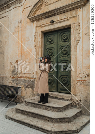 Young Woman Filming The Old Town Buildings With A Vintage Camera  126339306