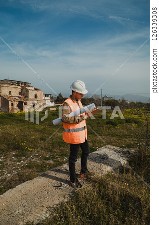 Engineer Walking On An High Spot To Watch The Construction Site From Above  126339308