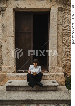 young Woman Reading The Bible On The Entrance Steps Of The Church 126339309
