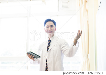 穿白大褂的男老師正在講課,看著相機 穿白大褂的男老師正在講課,看著相機 126339511