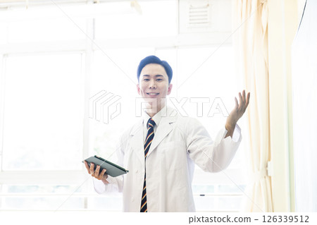 Male teacher in white coat giving a lecture, looking at camera Male teacher in white coat giving a lecture, looking at camera 126339512