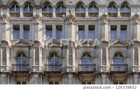 A stunning European style of Wrought iron black railings balconies and Classic glass windows in residential tenement building. A stunning European style of Wrought iron black railings balconies and Classic glass windows in residential tenement building. 126339652