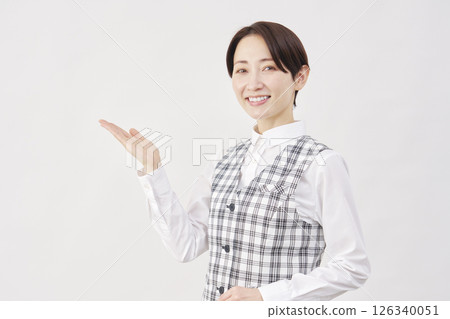 Female office worker pointing to the left with palm up, white background 126340051