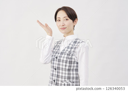 Female office worker pointing to the left with palm up, white background 126340053